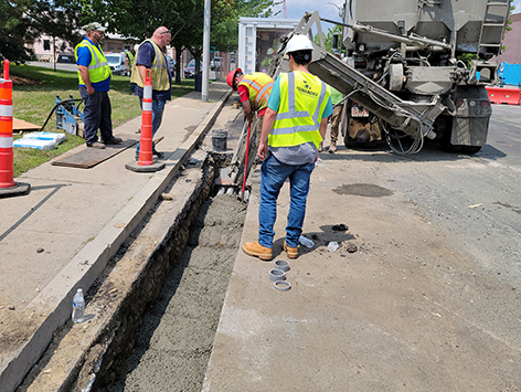 Restoring the south wall of manhole C19BA-203 by pouring concrete against the wooden cast formwork installed in the field.